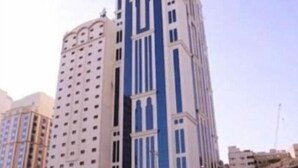 A tall, modern building with a white facade and blue accents. - Al Ebaa Hotel (Makkah)