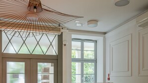 A kitchen with a modern design, featuring a unique wooden backsplash, a large window, and a ceiling fan. - RentPlanet - Lokum Vena (Wroclaw)