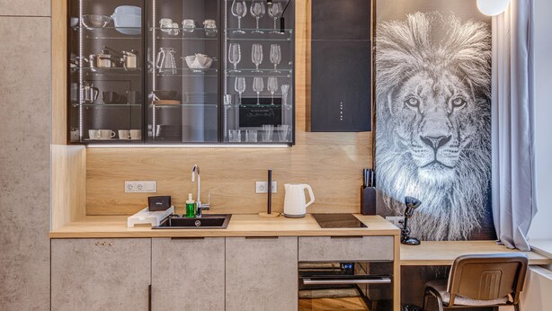 A modern kitchen with a built-in dishwasher, a coffee machine, and a large mirror above the counter. - RentPlanet - Lokum Vena (Wroclaw)