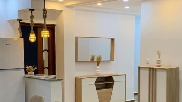 Une cuisine moderne avec un coin repas, comprenant une table en bois, des chaises et un meuble encastré.