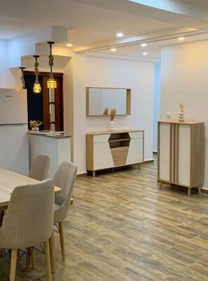 Eine moderne Küche mit Essbereich, ausgestattet mit einem Holztisch, Stühlen und einem Einbauschrank.