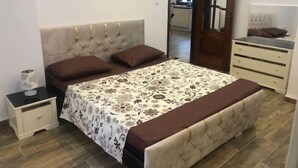 Une chambre à coucher comprenant un lit, une table de chevet, une commode et un miroir.