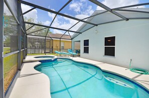 A swimming pool with a covered area, a hose, and lounge chairs.