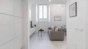 Una sala de estar moderna y minimalista con un sofá, una mesita auxiliar y una ventana con vistas.