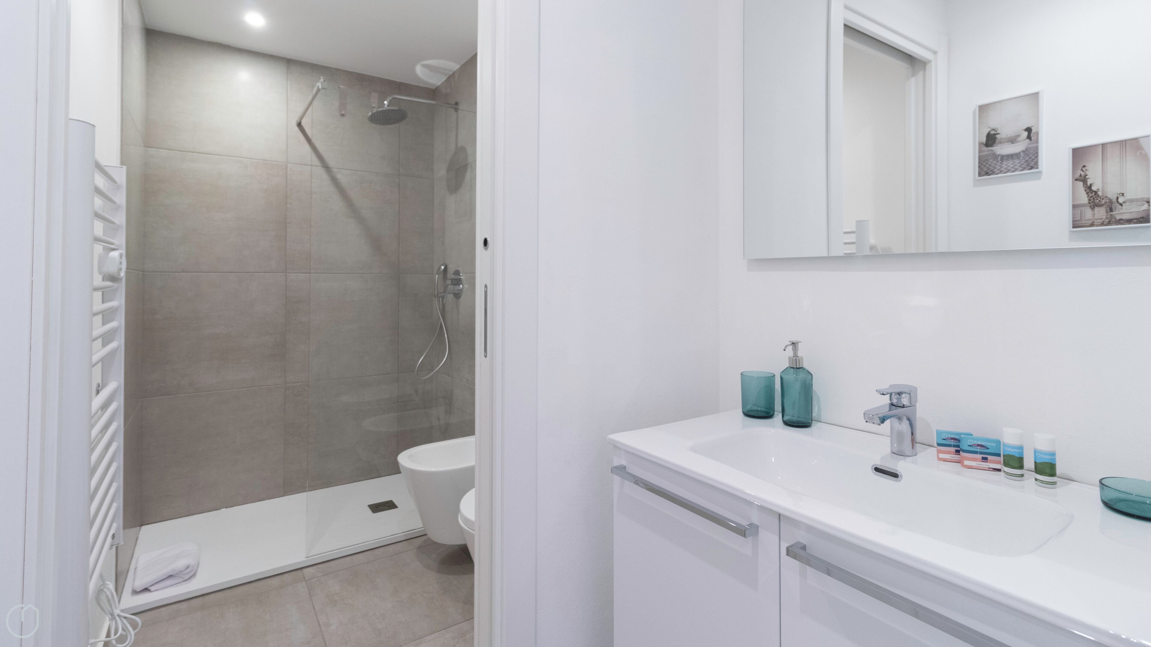 A modern bathroom with a shower, toilet, and sink.