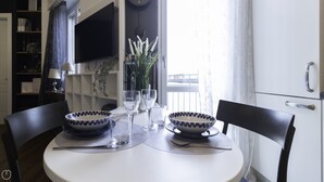 A dining table with two bowls, wine glasses, and a vase of flowers. - Italianway - Morosini 14 (Milan)