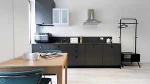 Una cocina moderna con microondas, hervidor y armarios.