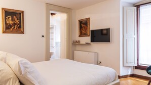 A bedroom with a bed, a television, and two paintings on the wall. - easyhomes - Annunciata (Milan)