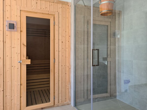 Una sauna con paredes de madera y puerta de cristal.