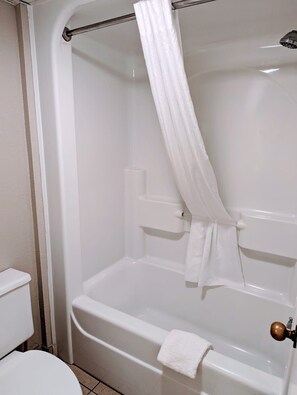 Bathroom features a bathtub with showerhead and toilet.