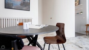 Een moderne eethoek met een ronde tafel, twee stoelen, een boek en een mok.