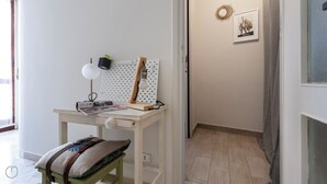 Een compact, opgeruimd werkgedeelte met prikbord, bureaulamp en een beklede bank.