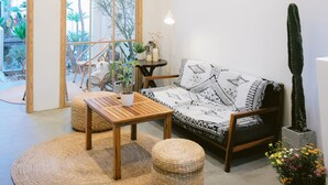 A cozy living room with a wooden ceiling, a ceiling fan, a sofa with patterned cushions, a coffee table, and a cactus plant. -  LaDa's House Da Nang (Da Nang)