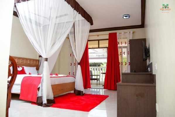 Un dormitorio con cama con dosel, alfombra roja y vistas al exterior.
