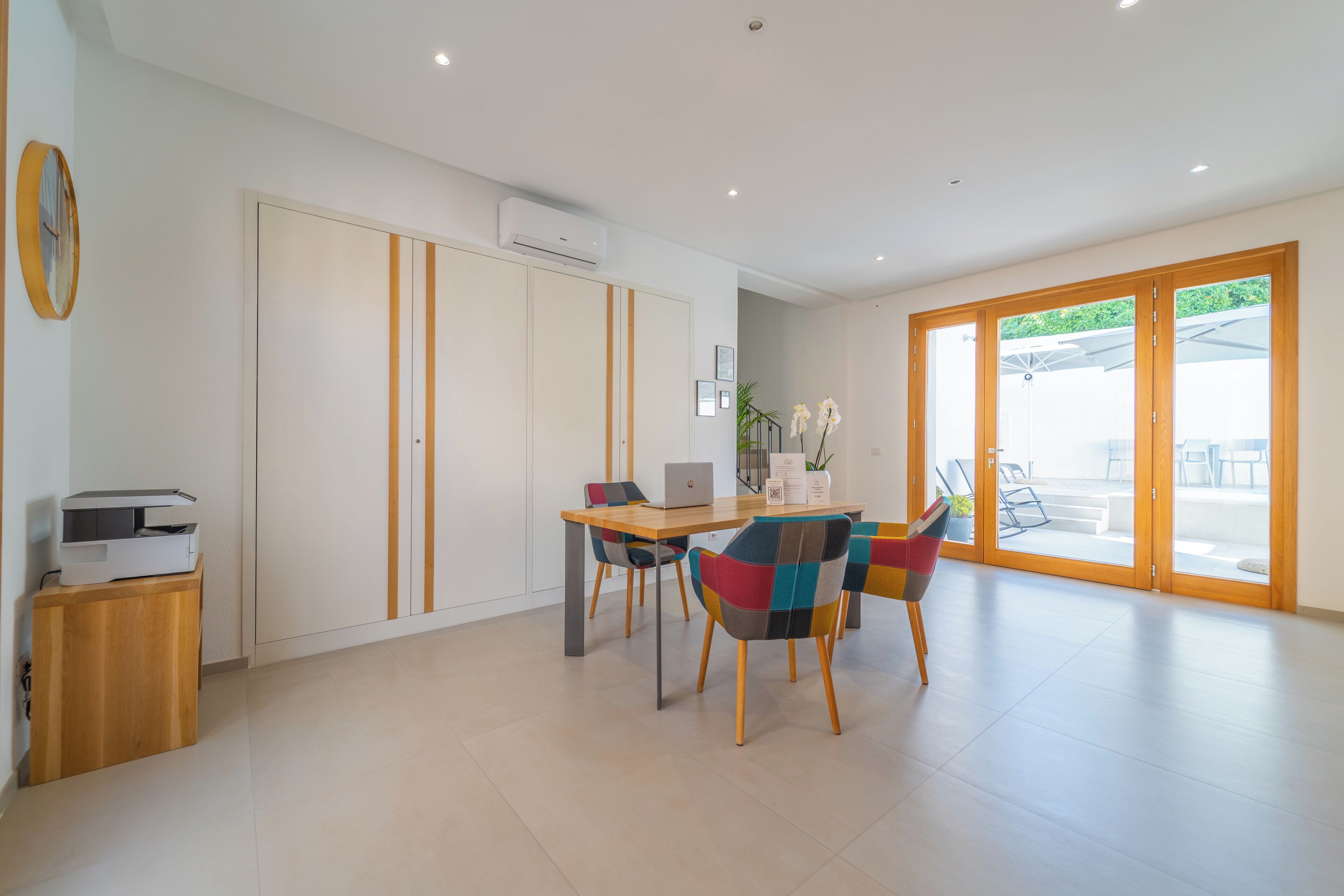 A modern room with a dining area, a printer, and a large window.