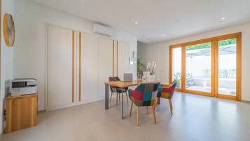 A modern room with a dining area, a printer, and a large window.