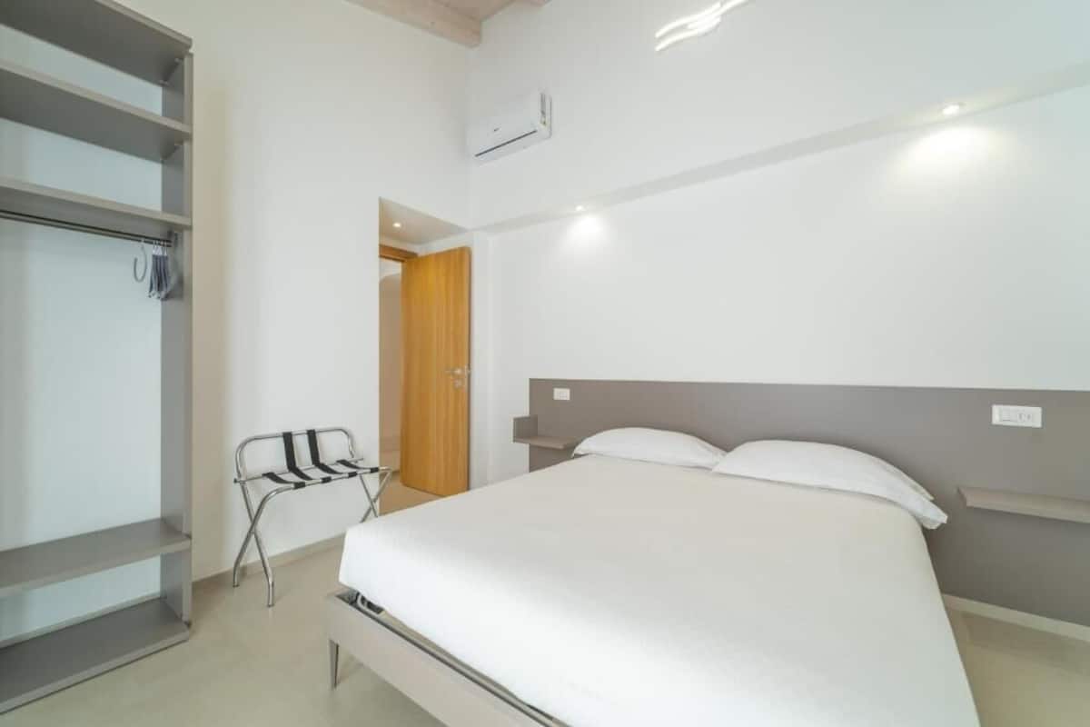 Un dormitorio con una cama, un armario y una silla.