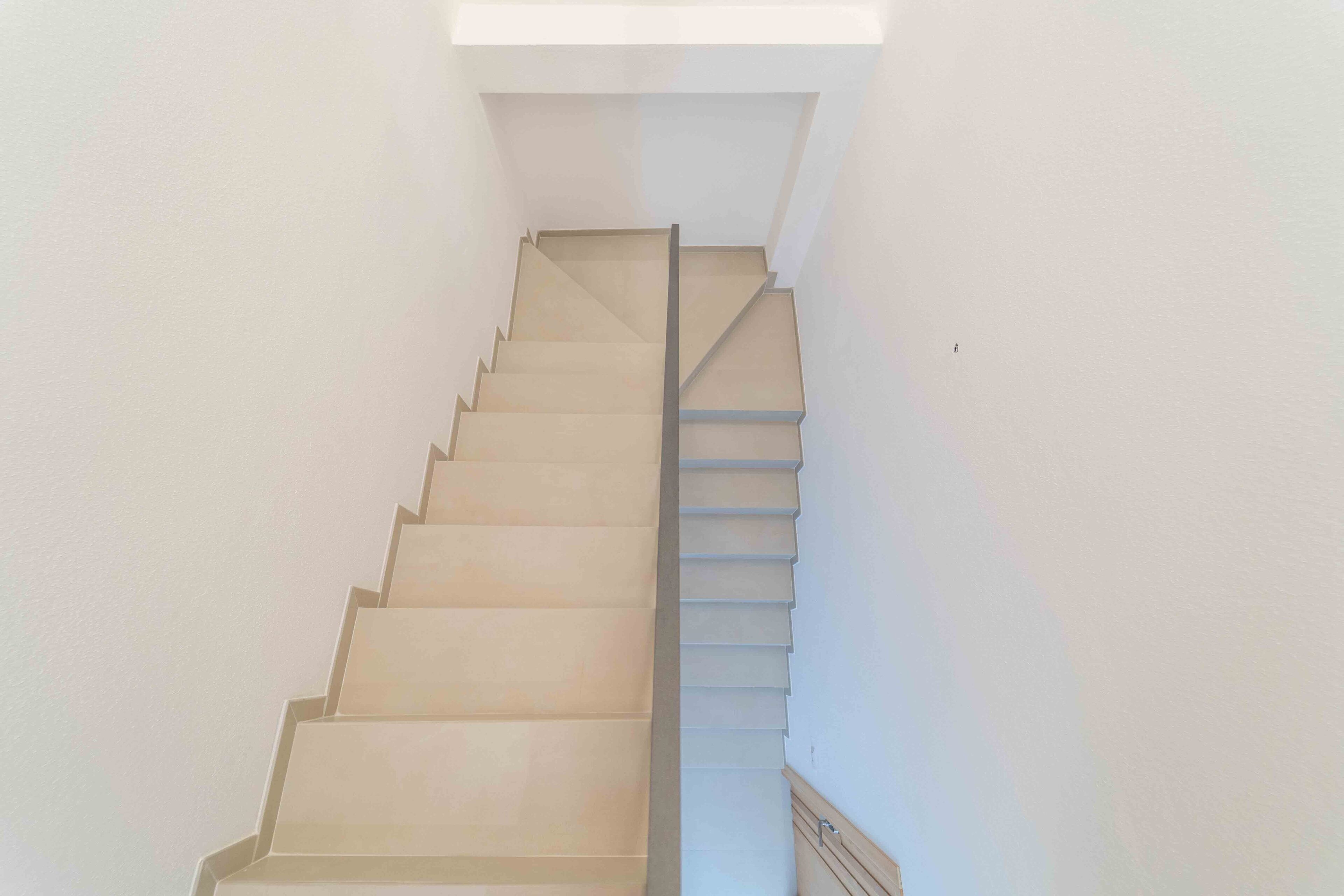 A staircase with a handrail and a light fixture at the top.