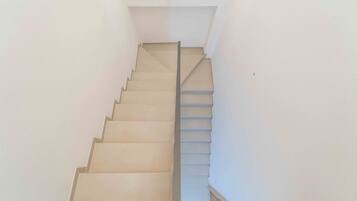 A staircase with a handrail and a light fixture at the top.