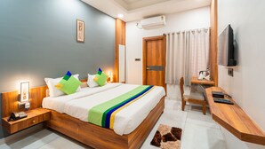 Ein modernes Hotelzimmer mit einem Holzbett, Nachttischen, einem Schreibtisch und einem Fernseher.