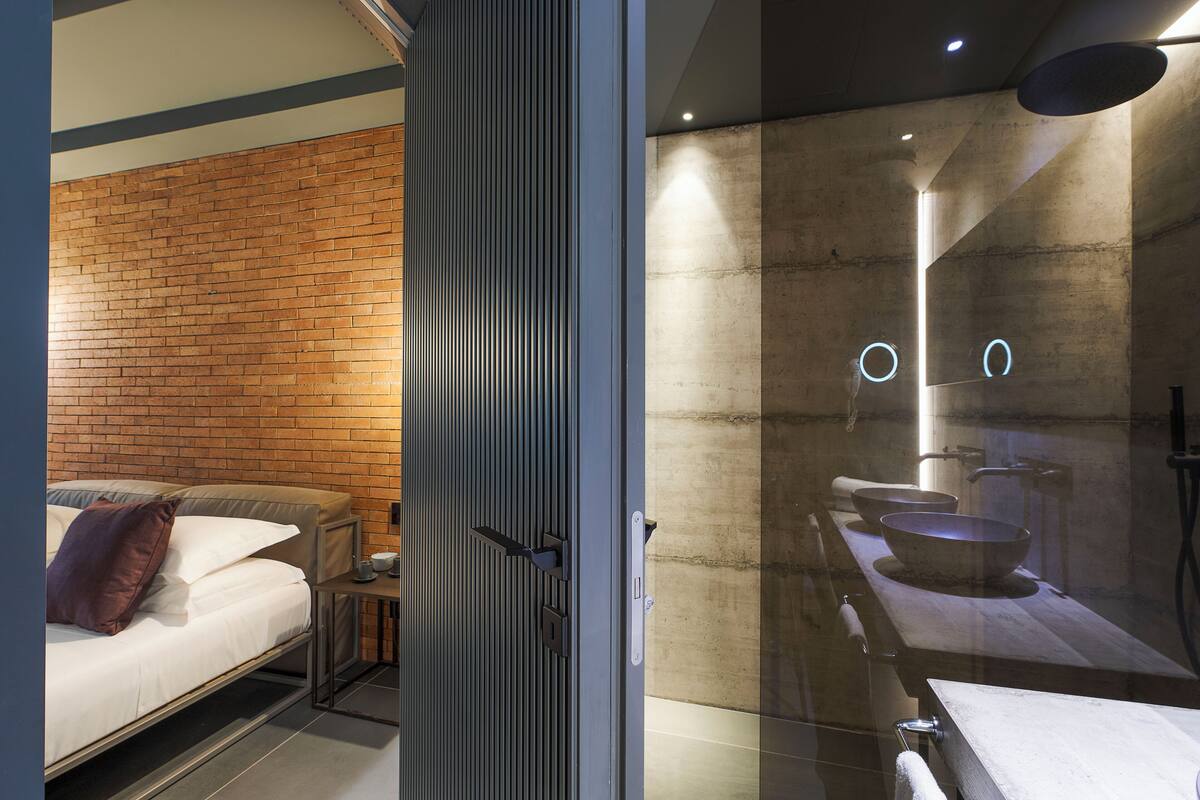 A modern bathroom with a large mirror, a bathtub, and a toilet.
