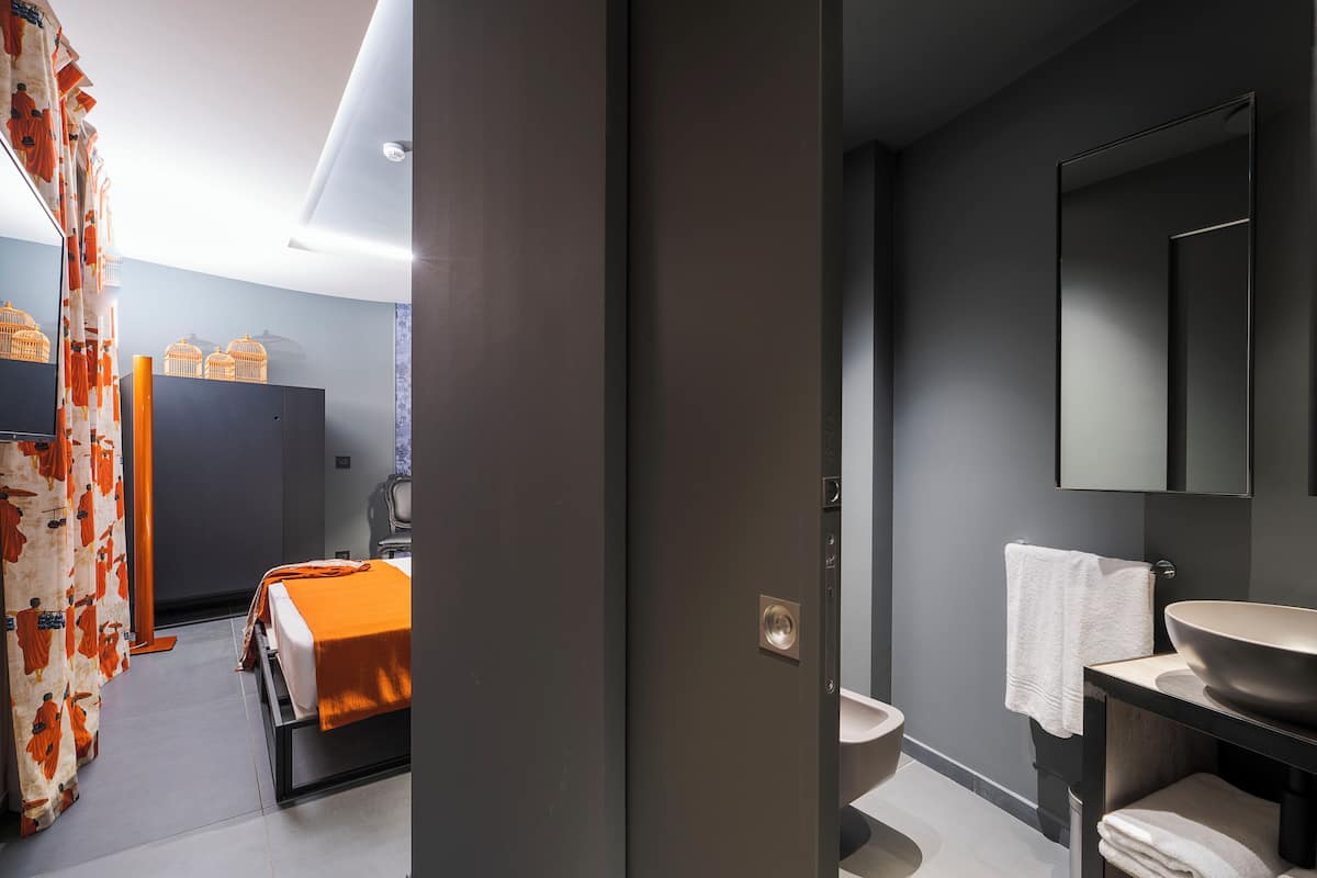 A modern bathroom with a large sink, a mirror, and a toilet.