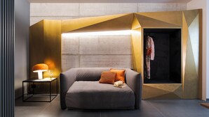 En moderne stue med en sofa, et sofabord med lampe og en indbygget garderobe.
