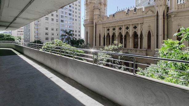 A modern building with a gothic architectural style, featuring pointed arches and a tower. - Apto 2 quartos no Centro de BH (Belo Horizonte)
