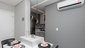 A modern kitchen with a white countertop, a built-in oven, and a grey backsplash. - Apto 2 quartos no Centro de BH (Belo Horizonte)