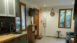 A compact kitchen with a wooden countertop, a built-in sink, and a television mounted on the wall. - The little house (Ceyreste)