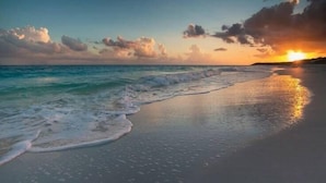 A beach with waves gently lapping onto the shore and a sunset in the background. - Hotel Soave Miriam (Rimini)