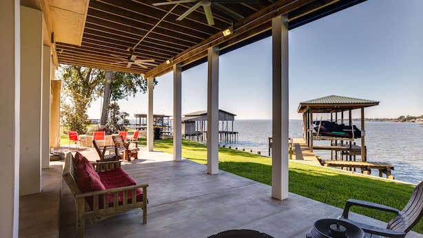 A covered outdoor seating area with a view of the water, wooden furniture, and a gazebo. - Spacious Lake Livingston Home w/ Decks & Fire Pit! (Livingston)
