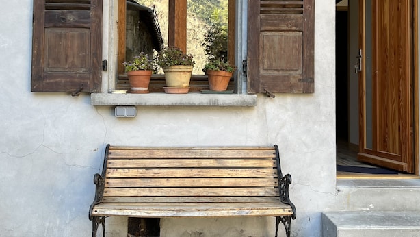 A wooden bench outside a building with a window overlooking a mountainous landscape. - Appartement Avec Sauna et Wifi, au Coeur du Village, Avec vue sur la Montagne (Le Bourg-d'Oisans)