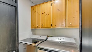 Una cocina con horno de acero inoxidable, lavavajillas empotrado y armarios de madera sobre los electrodomésticos.