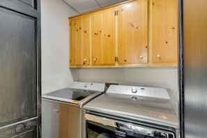Uma cozinha com forno de aço inoxidável, lava-louças embutida e armários de madeira sobre os eletrodomésticos.