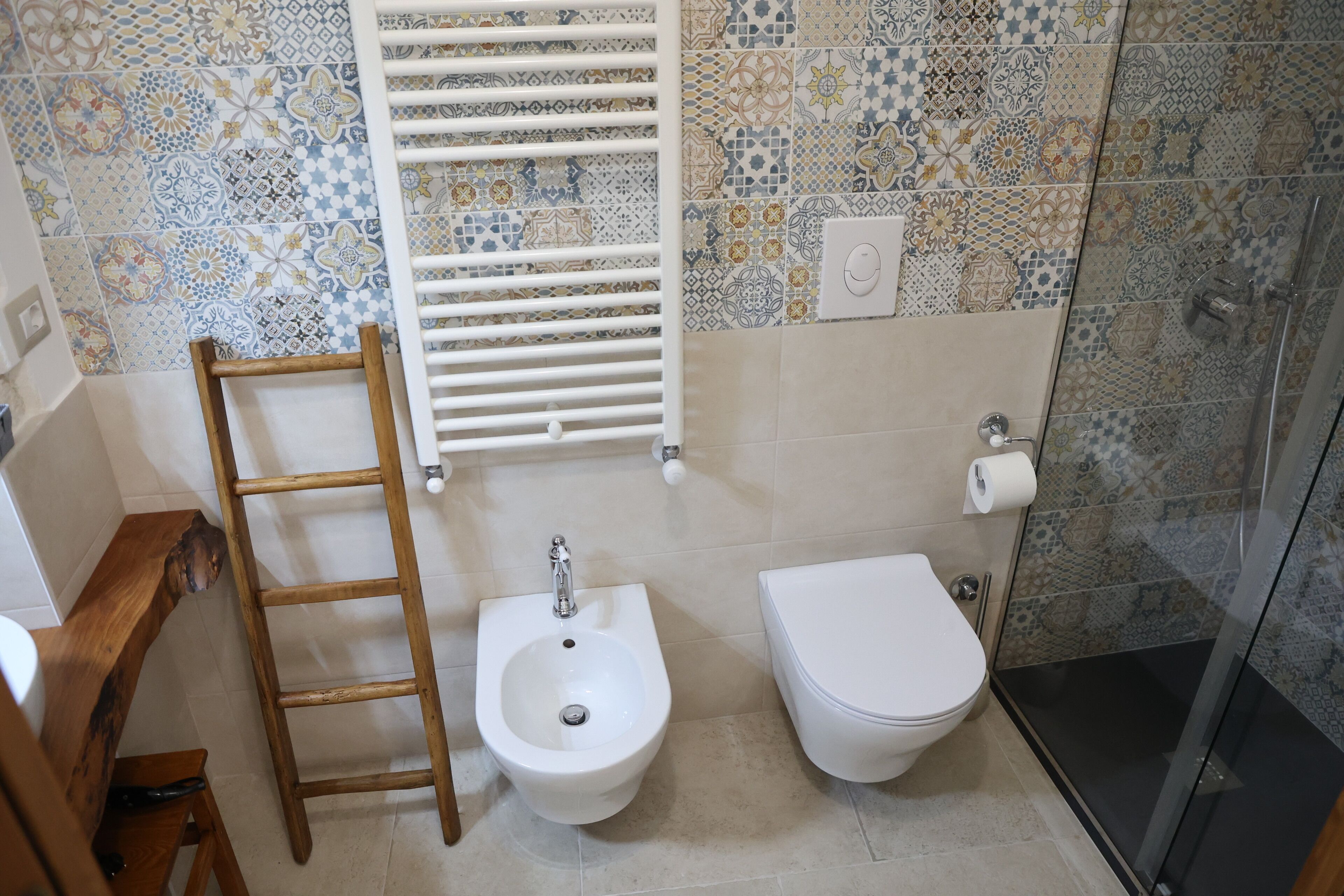 A bathroom with a bidet, toilet, and a shower.