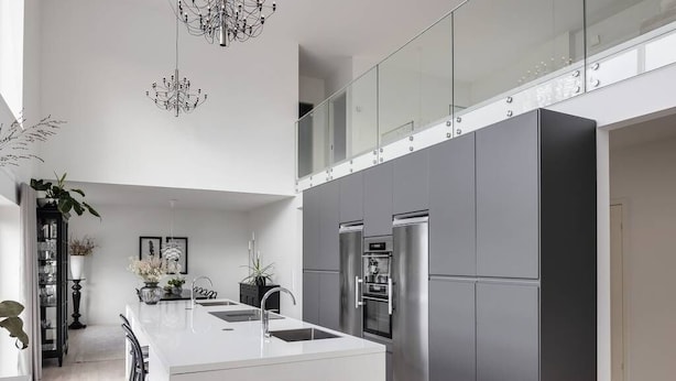 A modern kitchen with a central island, stainless steel appliances, and a glass railing overlooking a balcony. - Entire 2Bedroom villa plus jacuzzi 10 min to växjö (Alvesta)