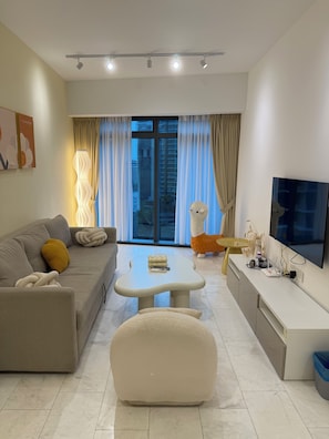 Departamento estándar, 1 habitación, para no fumadores, vista a la ciudad | Área de sala de estar | Televisión LCD de 55 cm con canales por cable y piso con calefacción 