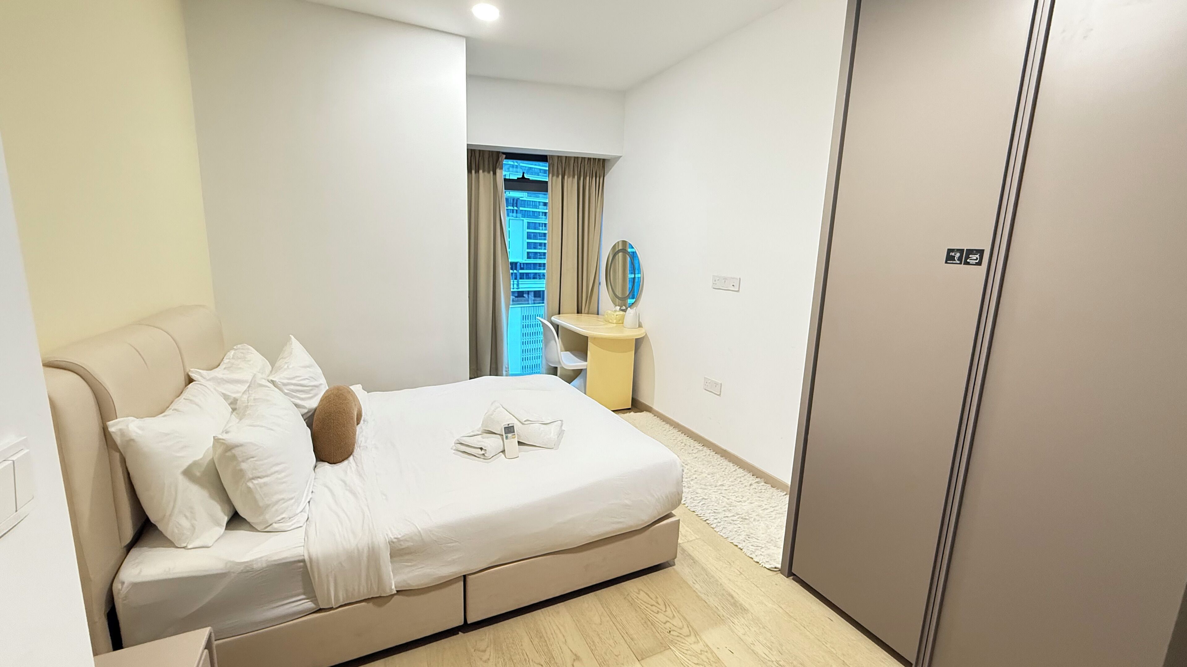 Ein Hotelzimmer mit Bett, Schreibtisch, Spiegel und Kleiderschrank.