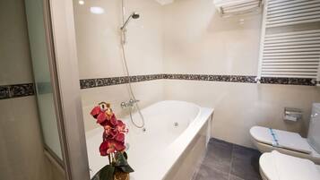 Junior suite | Badkamer | Een bubbelbad, een hydromassagedouche, gratis toiletartikelen