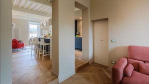 A modern interior with a dining area, kitchen, and a red sofa. - Casa Pino in Lucca With 2 Bedrooms and 2 Bathrooms (Lucca)