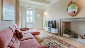 A living room with a sofa set, a television, a fireplace, and a decorative mirror. - Casa Pino in Lucca With 2 Bedrooms and 2 Bathrooms (Lucca)
