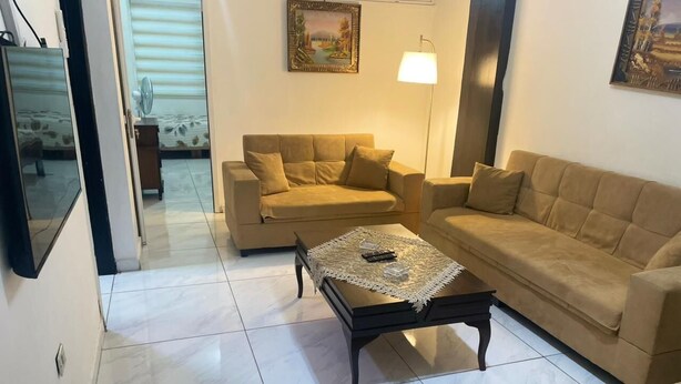 Un salon avec deux canapés beige, une table basse et un lampadaire.