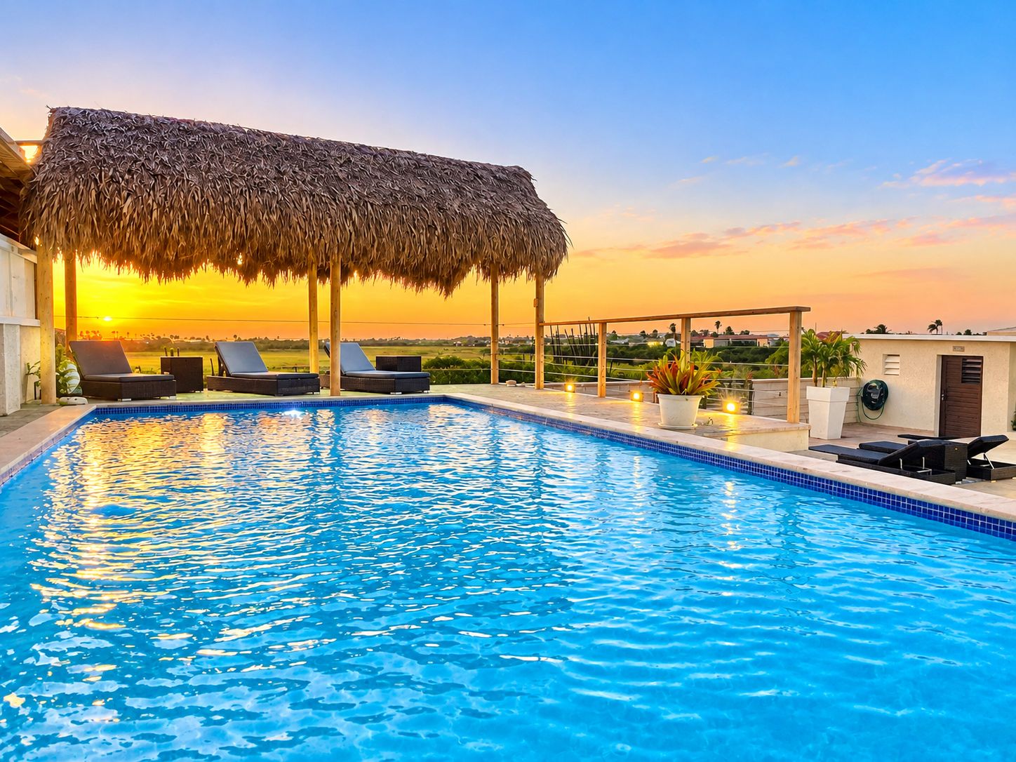 A swimming pool with lounge chairs and a thatched roof structure.