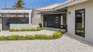 A modern house with a tiled roof, a gated entrance, and a landscaped garden. - Ruby On The Salina: Pool, Bar & Stunning View - 4 Minutes to Beaches! (Noord)