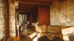 A cozy room with a stone wall, wooden ceiling, and a leather sofa.