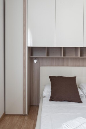 A bedroom with a bed, a brown pillow, a white headboard, and a wooden wardrobe. - Venice Grand Canal Style Apt 3 by Wonderful Italy (Venice)