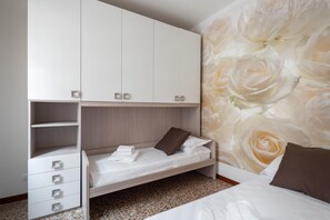 A bedroom with a bunk bed, a wardrobe, and a floral wallpaper. - Venice Grand Canal Style Apt 3 by Wonderful Italy (Venice)
