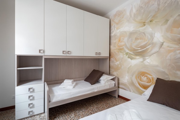 A bedroom with a bunk bed, a wardrobe, and a floral wallpaper. - Venice Grand Canal Style Apt 3 by Wonderful Italy (Venice)