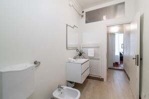 A modern bathroom with a toilet, sink, and mirror. There is a towel rack above the sink and a plant on the counter. - Venice Luxury Palace 12 by Wonderful Italy (Venice)